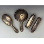 An early George V silver Arts and Crafts dressing table brush and mirror set, each planished and