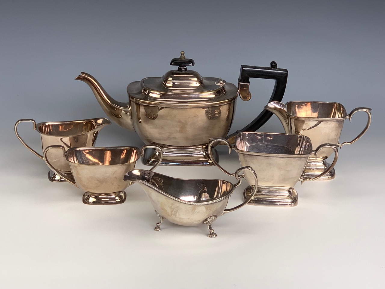 An electroplate three-piece tea set together with a sauce boat etc, second quarter 20th Century