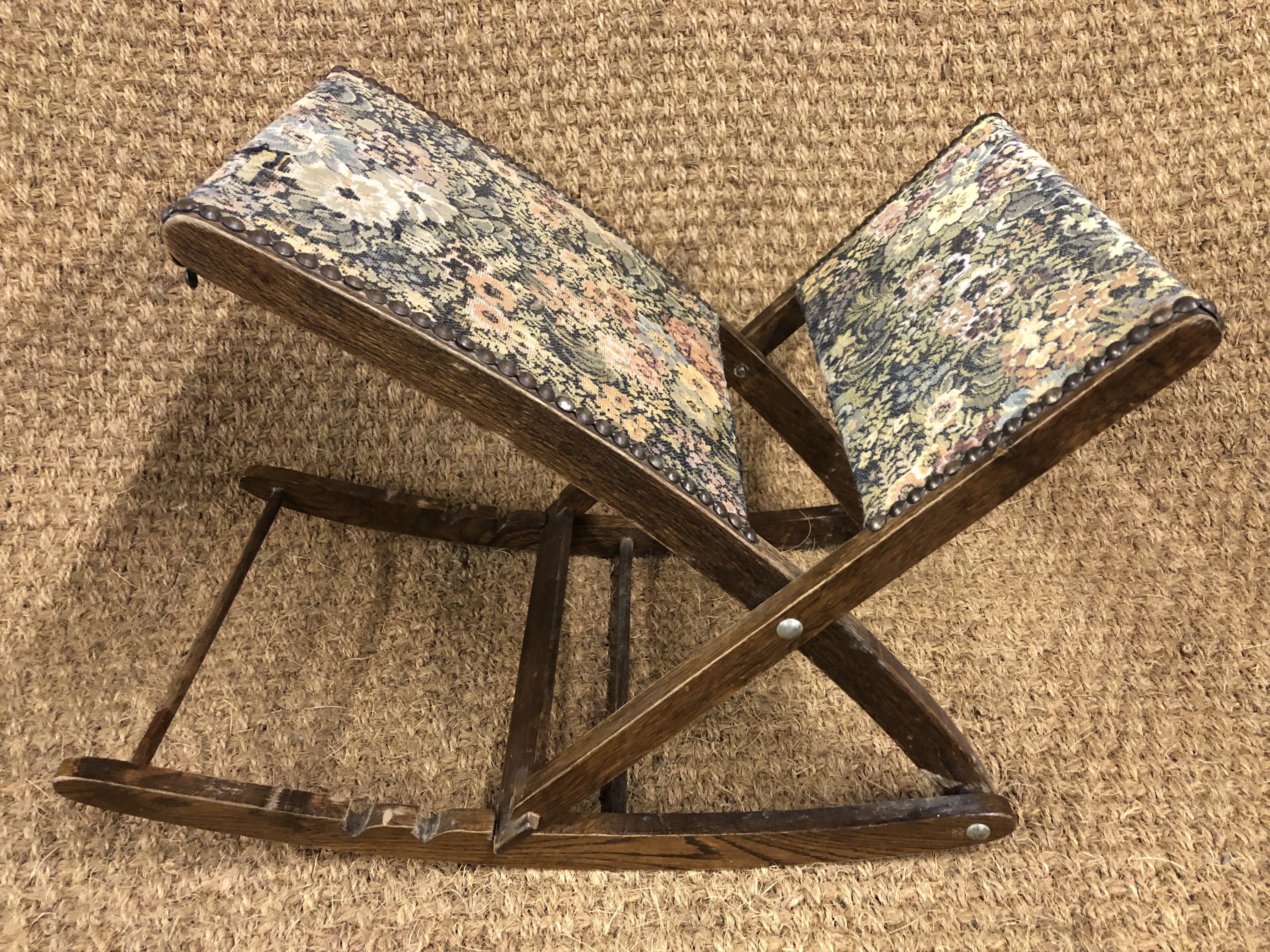 An upholstered oak adjustable gout stool