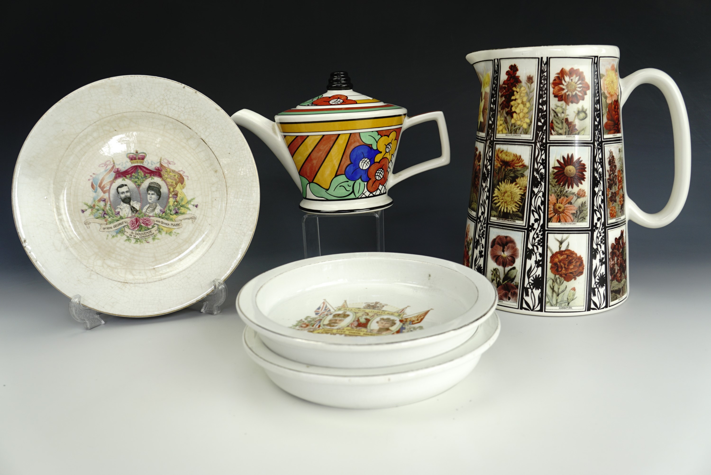 A Past Times teapot, a flower jug, two commemorative bowls and a plate