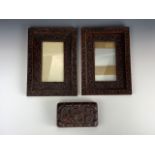 A pair of Anglo-Indian carved hard wood picture frames together with a carved wooden table box