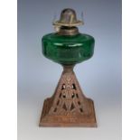 A Victorian oil lamp, having an emerald glass reservoir and cast pyramidal base