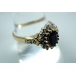 A 9ct gold sapphire and diamond flower head cluster ring, having a central sapphire of approximately