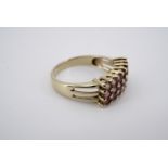 A contemporary 9ct gold and pink tourmaline statement ring, having three rows of pellet-set