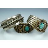 Two Egyptian bangles, each set with scarabs, and one other Middle eastern cabled bangle
