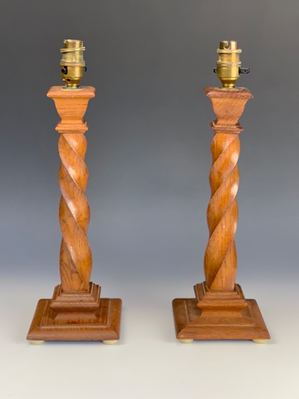 A pair of George V spirally fluted oak table lamps, 50 cm