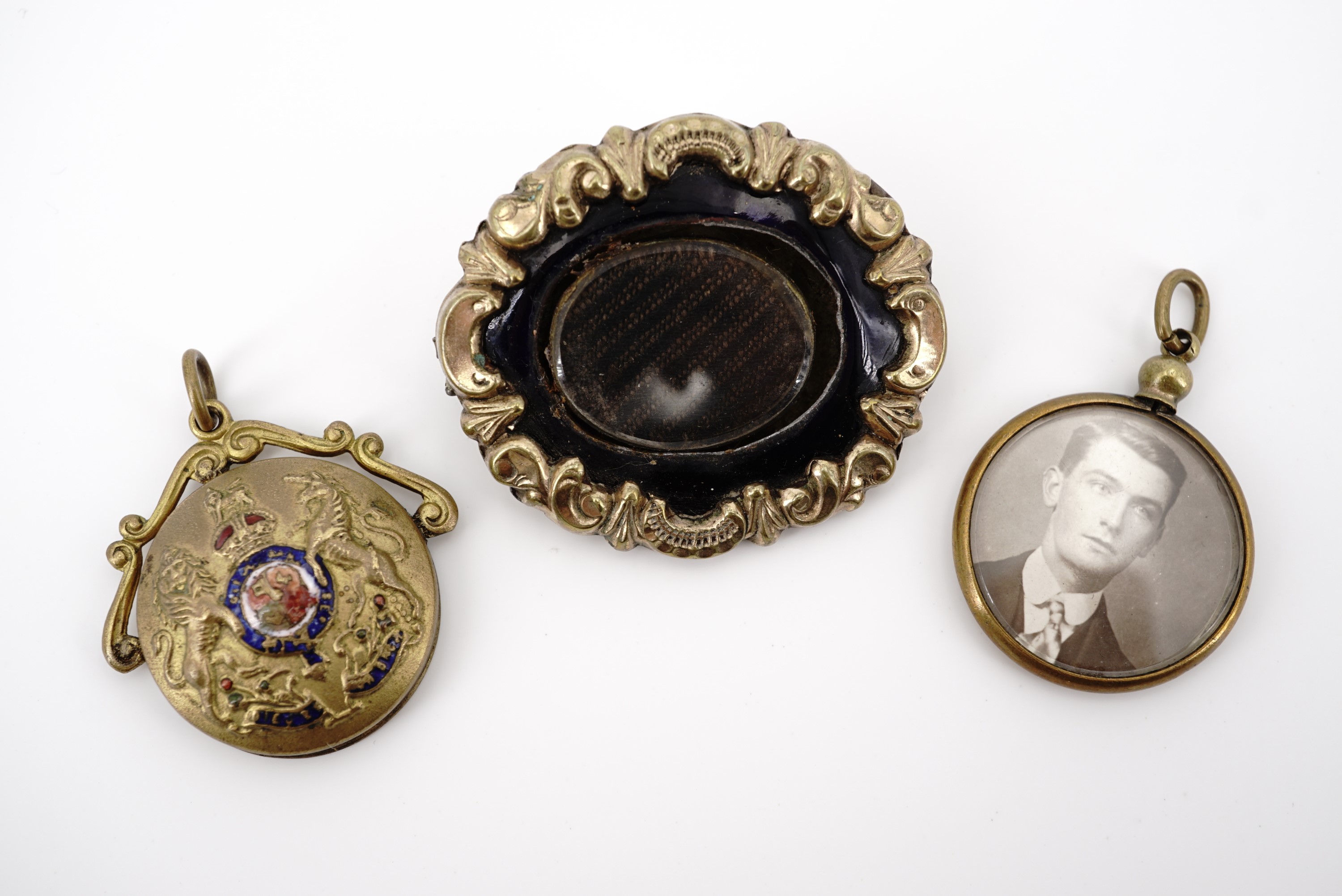 A Victorian rolled-gold hairwork locket brooch, a Great War sweetheart pendant locket, and one other