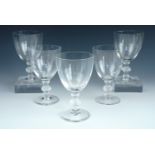 A set of five Lalique wine glasses, having moulded knopped stems, decorated with stylized foliage,