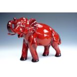 A Royal Doulton Flambe Ware elephant, modelled standing on all fours with trunk raised, 18 cm, old