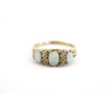 An early 20th Century opal and diamond ring, set with a central oval opal cabochon of approx .25 ct,