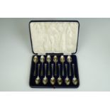 A cased set of twelve George VI silver coffee spoons, each with slender, guilloche engraved stems,