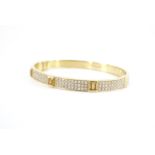 A contemporary yellow sapphire, diamond and 18 ct gold hinged bangle, comprising pairs of bar-set