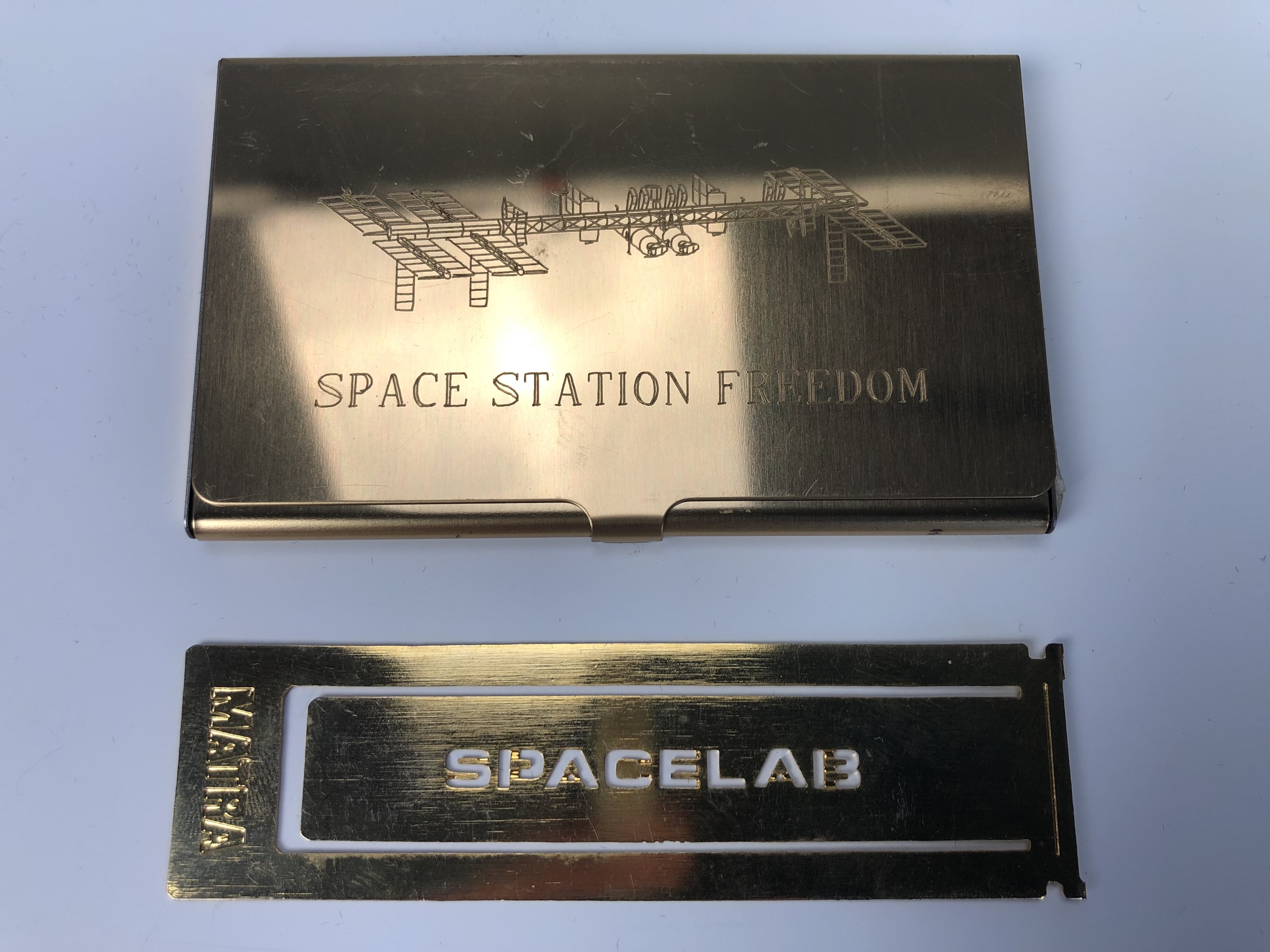 A Spacelab paper clip together with a Space Station Freedom business card case