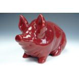 A Robert Heron and Sons Weymss Ware pottery pig, modelled in a seated position, with puce glaze,