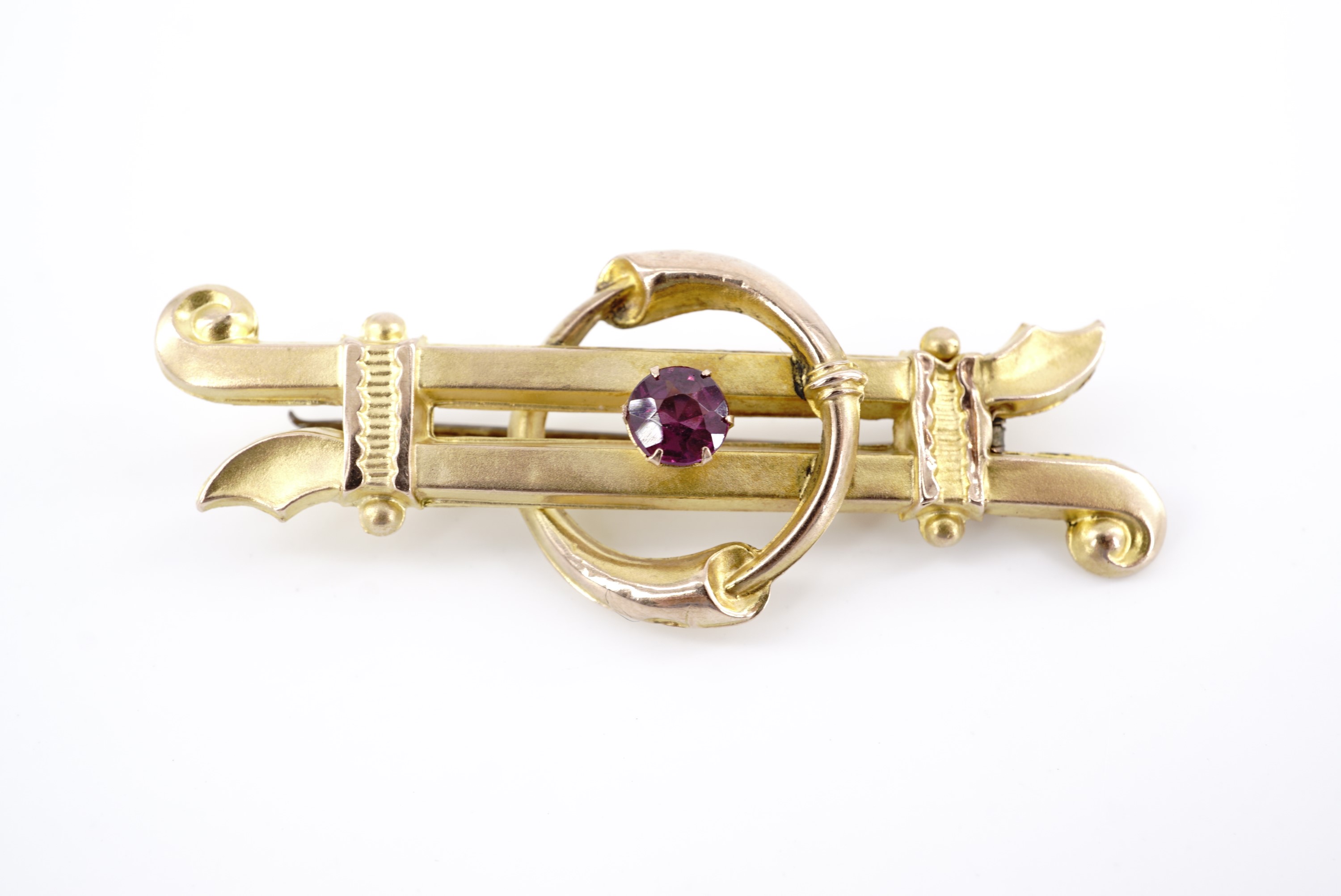 A Victorian almandine and 9 ct yellow metal bar brooch, the stone set within an annulus of inter-
