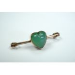 An early 20th Century jade brooch, comprising a collet-set heart-shaped cabochon set in a yellow