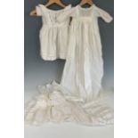 Four Victorian whitework garments for babies, including an 1840s dress with embroidered fan-shaped
