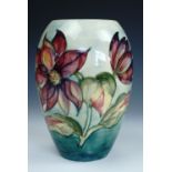 A William Moorcroft Clematis pattern vase, of ovoid form, having pink blossoms over a graded sea
