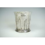 A 1920s silver beaker, of subtly tapering form with everted rim, decorated with pronounced ribs