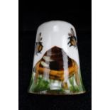 A Wemyss thimble hand decorated in depiction of bees around a skep, painted marks