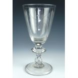 A Georgian glass baluster goblet, having a round funnel bowl and a knopped baluster stem with