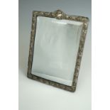 An Edwardian silver-framed dressing table mirror, the framed relief decorated in a spiral