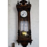 A late 19th Century Vienna wall clock, having a weight driven movement, in Neo-Baroque influenced