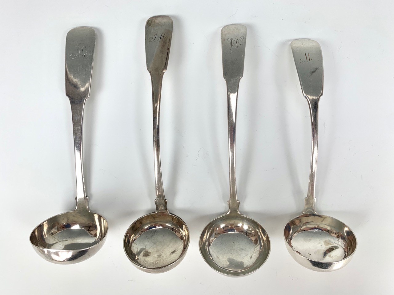 Four Georgian Scottish provincial silver sauce ladles, fiddle pattern, engraved with initials,