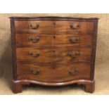 A George III serpentine fronted mahogany commode, having a plumb pudding top, the canted leading
