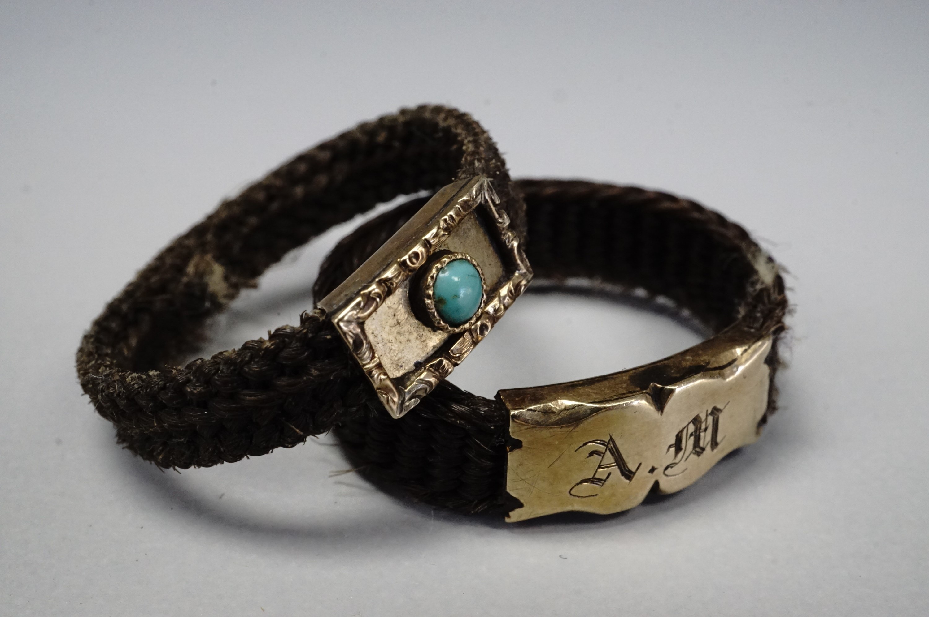 Two Victorian hairwork mourning rings, each having a yellow metal face, one bezel set with a