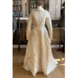 A 1950s ivory brocade wedding dress, having rounded collar, a button-down and gathered bodice, and a