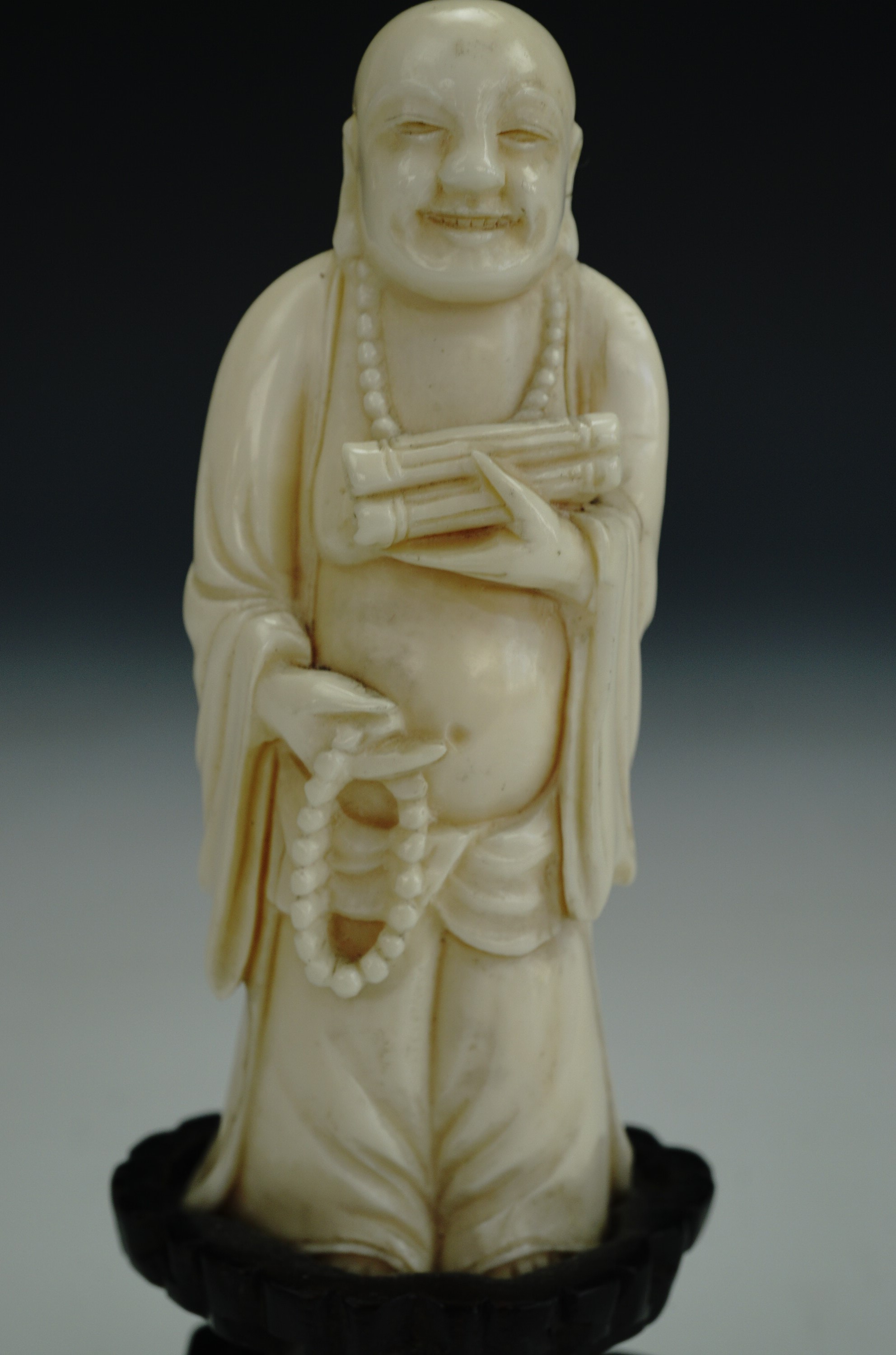 A late 19th / early 20th Century Chinese carved ivory figure of a standing Budai, in carved wooden - Image 2 of 3