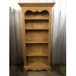 A contemporary reproduction Victorian pine open-fronted bookcase with moulded cornice and shaped