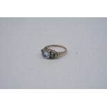 A blue topaz ring, comprising a central oval stone of approx. 8 mm x 6 mm framed by trios of smaller