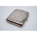 A 1918 Birmingham silver cigarette case with foliate scroll engraving and a vacant shield shaped