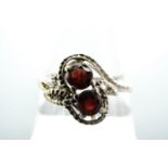 A twist-set red stone and 9 ct gold ring, the stones of approx, 5 mm within a beaded open-work and