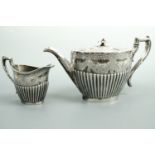 A Victorian electroplate teapot and milk jug with engraved floral pattern
