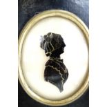 A pair of 19th Century silhouettes reverse painted on domed glass, depicting a young lady and