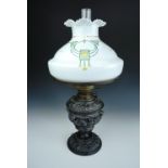 An antique German Kosmos Brenner Baroque style base metal oil lamp, the base incorporating winged