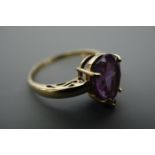 An amethyst and 9 ct gold ring, the pendeloque cut stone of approx. 12 mm x 8 mm claw set on 9 ct