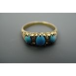 An antique turquoise and diamond ring, comprising three oval turquoise cabochons divided by pair