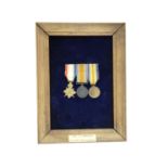 A framed Great War trio of miniature medals, the frame bearing a label with typewritten
