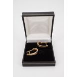 A pair of contemporary diamond and 9 ct gold hoop earrings, each channel-set with nine diamond