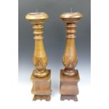 Two large carved hardwood candle sticks (a/f), 26 cm