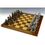 A resin Chinese figural chess set (king's 13 cm), with board