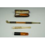 Two late 19th / early 20th Century amber pipe holders, an antique Canton Ivory cigarette holder