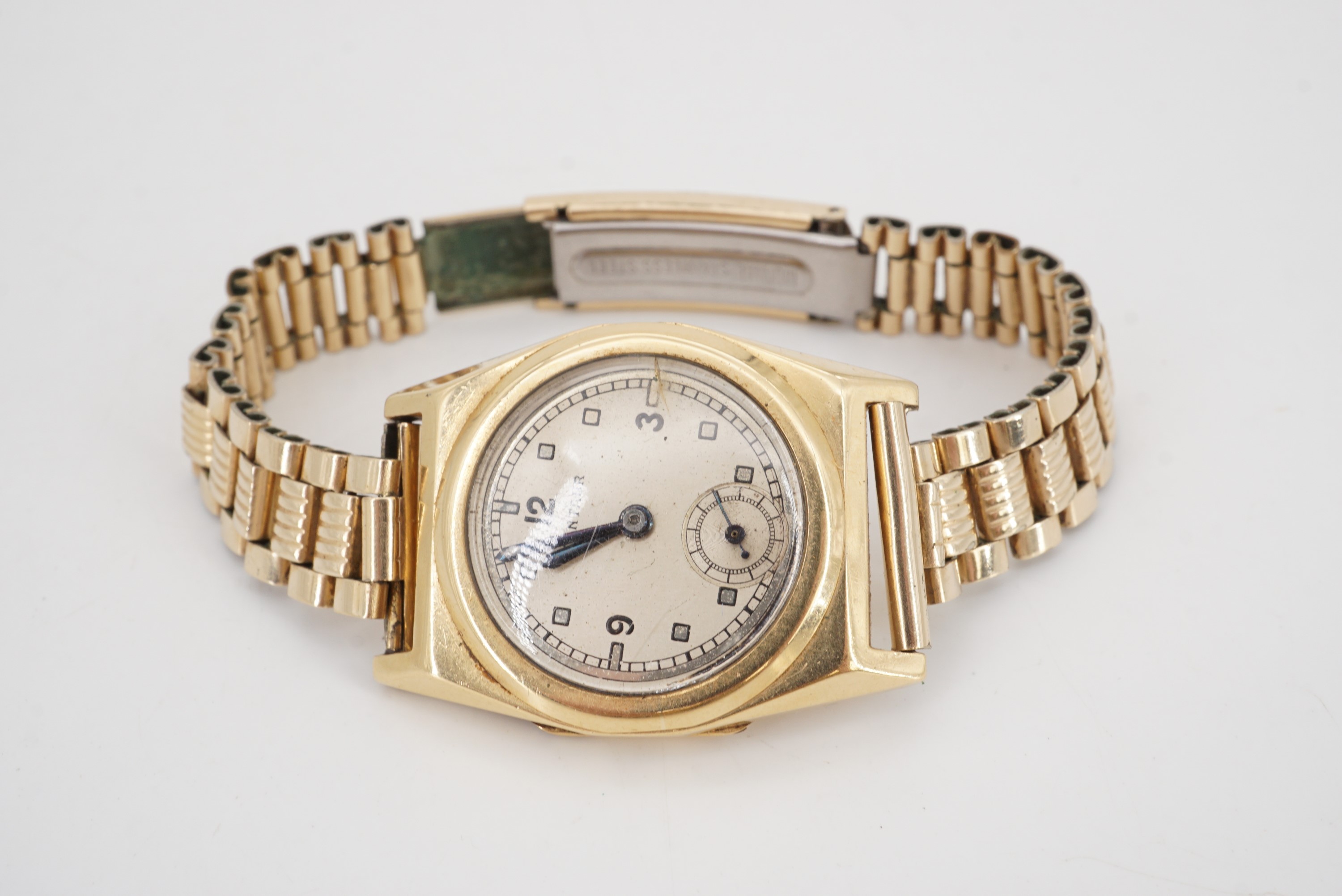 A 1930s Centaur 18ct gold wristwatch having a tonneau shaped case on a rolled gold bracelet strap,