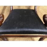 A George IV mahogany dining armchair, having a tablet back, scroll arms and reeded front legs, the