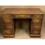 A reproduction George III hardwood pedestal desk, having an inset tooled brown leather writing