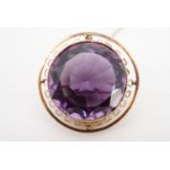 A yellow metal mounted amethyst brooch, the circular facet-cut stone of approximately 2 cm diameter,